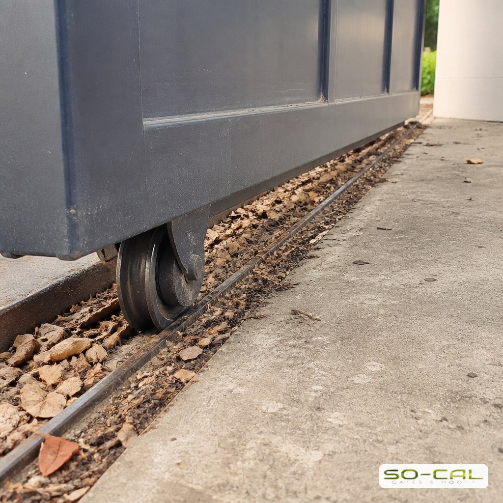 Debris built up in a sliding gate ground track