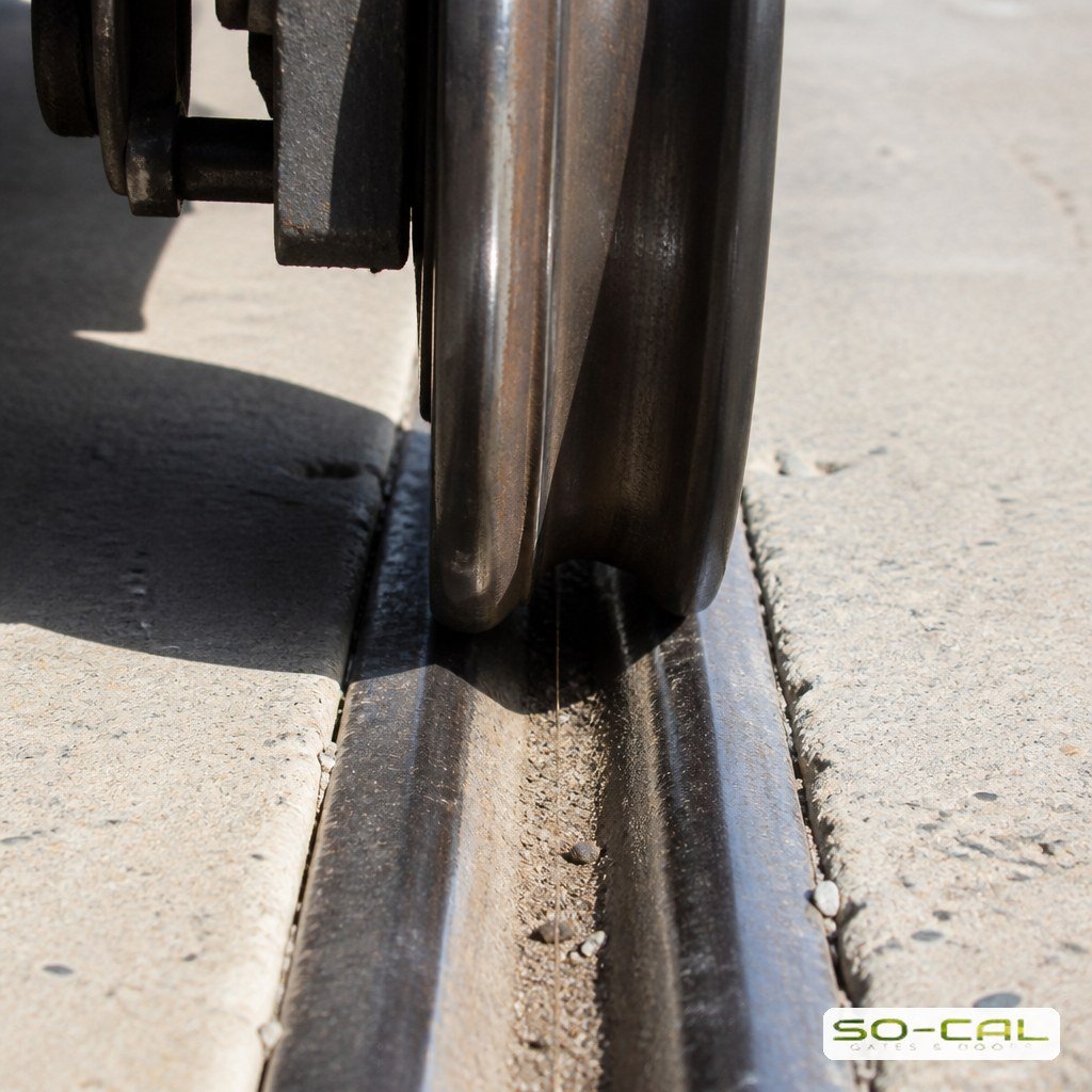 V-groove wheel on a ground track rail with grit packed into the groove